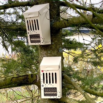 In elkaar gezet bijenhotel buiten opgehangen in een bijvriendelijke tuin.