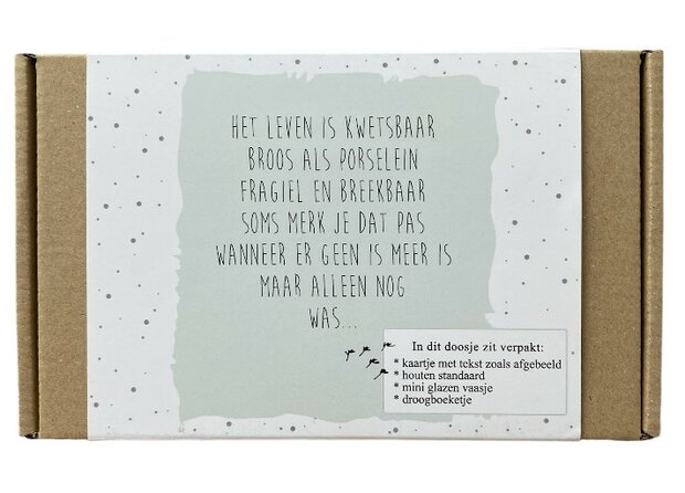 Kaartje met de tekst: "Het leven is kwetsbaar broos als porselein…" in houten houder.